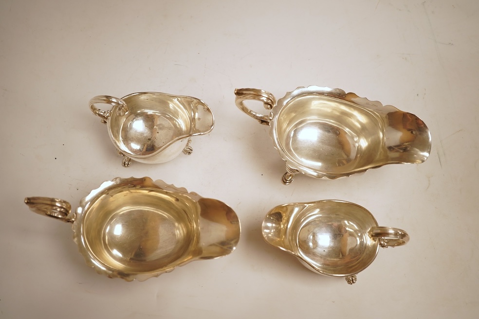 A pair of George V silver sauceboats, with cut borders and flying scroll handles, on three hoof feet, by J.B. Chatterley & Co Ltd, Birmingham, 1928, length 19.3cm, 19.3oz, together with a pair of silver plated Elkington